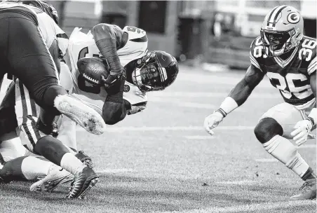  ?? Photos by Brett Coomer / Staff photograph­er ?? Damarea Crockett, left, dives toward the goal line as Packers safety Raven Green defends during Thursday’s game at Green Bay.