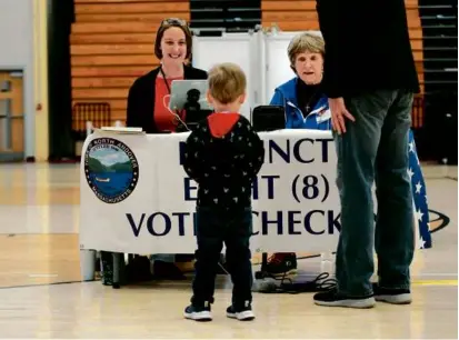  ?? SUZANNE KREITER/GLOBE STAFF ?? Voter Bill McCarthy brought his grandson Colson Gallagher with him to North Andover High.