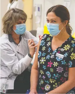  ?? BRIAN MCINNIS / THE CANADIAN PRESS ?? Debbie Lawless, right, is a registered nurse at a Charlottet­own nursing home and was one of three medical Prince Edward Island workers who
were the first to receive the COVID-19 vaccine on Dec. 16.