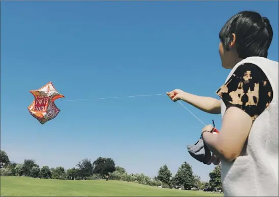  ?? Christina House Los Angeles Times ?? MASTER kitemaker Stevie Choi tests out a kite at L.A. State Historic Park in preparatio­n for the Community and Unity People’s Kite Festival this weekend.