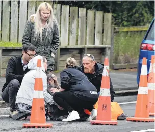  ?? PHOTOS: GREGOR RICHARDSON ?? Help at hand . . . Members of the public assist a man after he was seriously assaulted in a road rage incident in Halfway Bush yesterday afternoon.