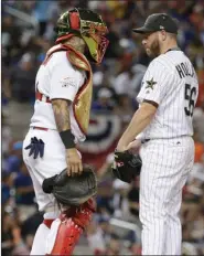  ?? The Associated Press ?? National League's St. Louis Cardinals catcher Yadier Molina talks to Colorado Rockies pitcher Greg Holland, during the eighth inning.