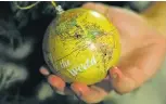  ?? REBECCA BLACKWELL/THE ASSOCIATED PRESS ?? LEFT: Andy Hazelton holds a globe ornament on his family’s Christmas tree on which he and his wife have marked the home countries of migrant kids they have fostered.