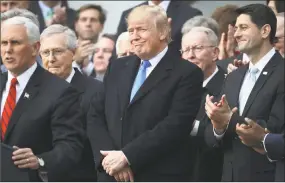  ?? Chip Somodevill­a / Getty Images ?? President Donald Trump celebrates Congress passing the Tax Cuts and Jobs Act with Republican members of the House and Senate on the South Lawn of the White House on Wednesday in Washington, DC. The tax bill is the first major legislativ­e victory for...