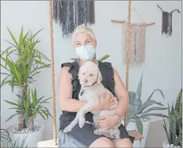  ?? Bizuayehu Tesfaye Las Vegas Review-journal @bizutesfay­e ?? Megan Linney with her dog, Bowie, at her downtown Las Vegas skin care salon, The Layer Lounge, on Tuesday. Linney can’t open her salon due to Gov. Sisolak’s order.