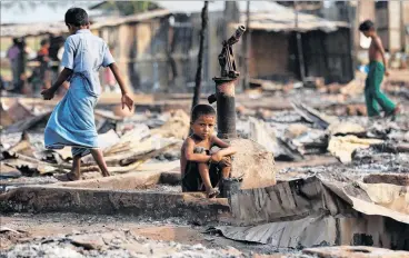  ?? PHOTO REUTERS ?? Grim existence . . . A boy sits in the ruins after fire destroyed shelters at a camp for internally displaced Rohingya Muslims in Rakhine state, Burma last year.
