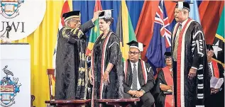  ??  ?? UWI Chancellor Sir George Alleyne ‘caps’ Dr Luz Longsworth during the final stage of the induction ceremony officially declaring her pro vice-chancellor and principal, UWI Open Campus. Sharing in the occasion are her colleagues, including Sir Hilary...