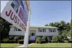  ?? ASSOCIATED PRESS ?? A for sale sign hangs in front of a house.