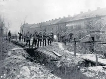  ??  ?? German soldiers walking freely out of the trenches on Christmas Day 1914 in the village of Frelinghie­n where German troops rolled two barrels of beer over during the truce as a gift for soldiers of Royal Welch Fusiliers