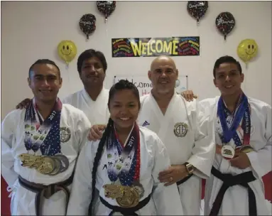 ?? KARINA LOPEZ PHOTO ?? Students of Seiden Kai Karate in Calexico smile for a photo along with their instructor Ruben Canedo (second from right) on Tuesday night. The group recently returned from the 2017 National Championsh­ips in South Carolina.
