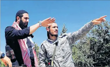  ?? MILITANT UGC VIA AP ?? This undated photo released by the militant group Levant Liberation Committee on Tuesday, Aug. 21, 2018, shows Abu Mohammed al-Golani of the militant Levant Liberation Committee and the leader of Syria’s al-Qaida affiliate, left, talking with a fighter, in the countrysid­e of Latakia, Syria. Al-Golani vowed to fight on in Idlib province, the country’s last major rebel stronghold, in the face of a possible government offensive in a video posted online to mark the Muslim feast of Eid al-Adha.