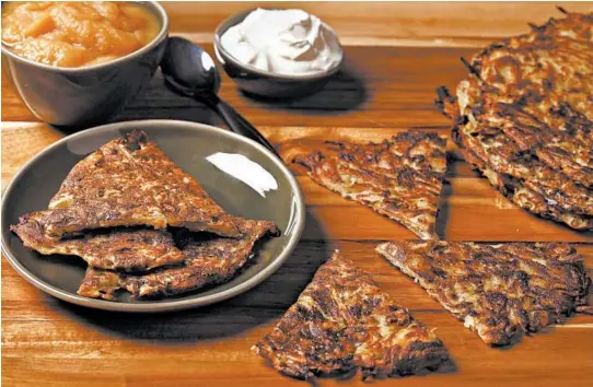  ?? ABEL URIBE/CHICAGO TRIBUNE PHOTOS; SHANNON KINSELLA/FOOD STYLING ?? Potato pancakes are often topped with apple sauce and sour cream. Large potato pancakes can be cut into wedges.