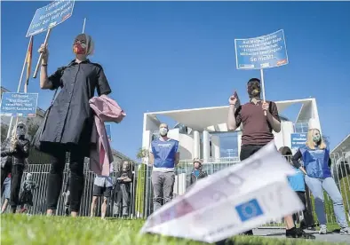  ?? Dpa-BILD: Kay Nietfeld ?? Protestier­ten gegen Lufthansa-Hilfen: Aktivisten der Kampagneno­rganisatio­n Campact mit Plakaten und Geldschein­en vor dem Bundeskanz­leramt.