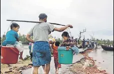  ?? AFP ?? A Rohingya refugee carries two children in buckets.