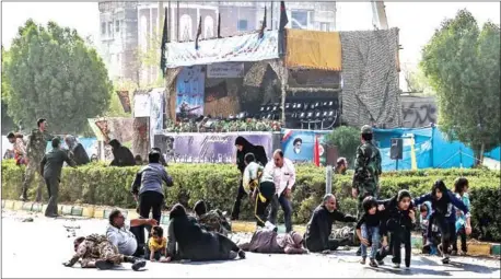  ?? MORTEZA JABERIAN/AFP ?? Iranian men, women and children lie on the ground with some seeking cover at the scene of an attack on a military parade in Ahvaz in Iran on Saturday.