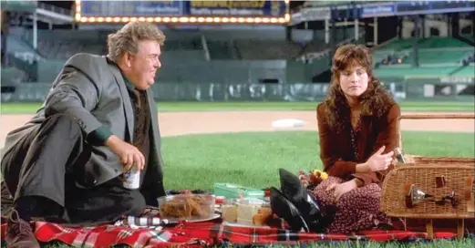  ??  ?? TWENTIETH CENTURY FOX Danny ( John Candy) treats Theresa ( Ally Sheedy) to a picnic on the field at Comiskey Park in “Only the Lonely.”