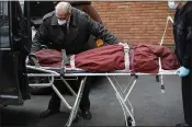  ?? JOHN MINCHILLO — THE ASSOCIATED PRESS ?? Personnel deliver a body to a funeral home Friday in New York. The city’s death toll has risen to over 4,000.