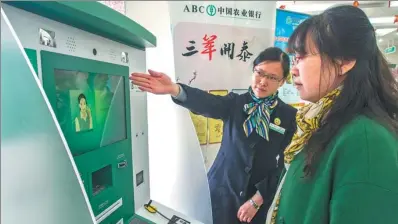  ?? FENG JIANGJIANG / FOR CHINA DAILY ?? An employee of Agricultur­al Bank of China Ltd helps a client at an outlet of the bank in Zhenjiang, Jiangsu province.