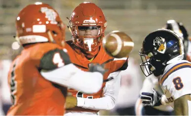  ?? STEPHEN M. KATZ/STAFF ?? Lake Taylor’s Jeffrey Foster pitches the ball to Chuck Fisher as Maury’s Dajon Evans closes in during Friday night’s game in Norfolk. The host Titans beat the Commodores 27-14 after losing to them 49-7 in their last meeting.