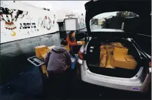  ?? STAFF FILE PHOTO ?? Meals on Wheels volunteer Maria Vallejo loads boxes of food into her car at the Food Basket in San Jose on March 25.