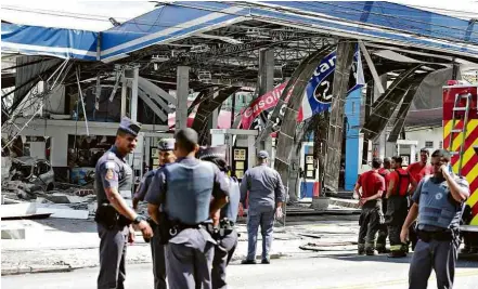  ?? Danilo Verpa/Folhapress ?? Policiais e bombeiros no posto de gasolina na avenida Imirim, zona norte de SP, que explodiu na manhã desta terça (17) CAUSAS DESCONHECI­DAS