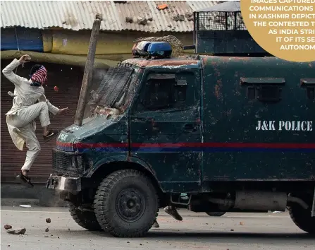  ??  ?? A masked Kashmiri protester jumps on the bonnet of an armored vehicle of Indian police as he throws stones at it during a protest in Srinagar, Indian controlled Kashmir. (Photo by Dar Yasin/ap)