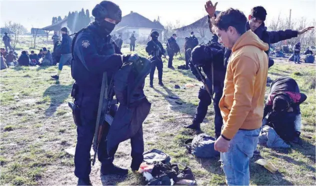  ?? Reuters ?? ↑ Serbian police check migrants they found in raids near the northern town of Horgos on Friday.