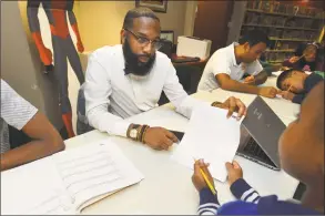  ?? Alex von Kleydorff / Hearst Connecticu­t Media ?? Counselor Donavan Tracey helps kids with their math skills at the South Norwalk branch of the Norwalk Public Library on Tuesday.