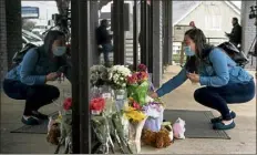  ?? ELIJAH NOUVELAGE / GETTY IMAGES ?? Lijing Zhao, owner of Jo Jos Massage, lays a bouquet of flowers Wednesday outside the spa where four people were shot and killed on Tuesday in Acworth, Ga.