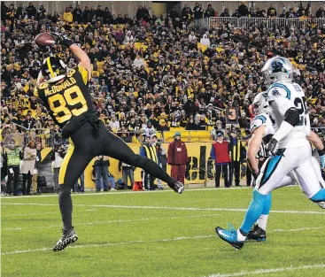  ?? — THE ASSOCIATED PRESS ?? Vance McDonald hauls in one of five TD passes thrown by Ben Roethlisbe­rger in the Steelers’ 52-21 rout Thursday over the Panthers in Pittsburgh.