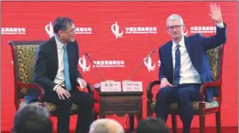  ?? FENG YONGBIN / CHINA DAILY ?? Apple CEO Tim Cook (right) talks with Professor Qian Yingyi, dean of School of Economics and Management, Tsinghua University, during the 18th China Developmen­t Forum in Beijing on March 18.