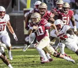  ?? MARK WALLHEISER AP ?? Florida State quarterbac­k McKenzie Milton, who passed for 248 yards and one touchdown Saturday, evades several Louisville tacklers for a big gain.