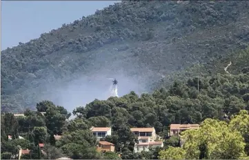  ?? (Photos P.H.C) ?? Peu après  heures, deux hélicos ont enchaîné les largages. L’incendie a pu être maîtrisé en moins d’une heure. Le massif est sauvé malgré les rafales mais les flammes ont emporté l’abri de jardin et le mimosa des riverains, évidemment sous le choc