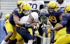  ?? Raymond Thompson/Associated Press ?? West Virginia linebacker Xavier Preston (53) tackles running back Donte Thomas-Williams in the Mountainee­rs spring game Saturday in Morgantown, W.Va.