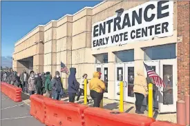  ?? WELSH-HUGGINS/ASSOCIATED PRESS FILE PHOTO] ?? In this Friday photo, people bundled against the cold stand in a slowly moving line to cast early votes at the Franklin County Board of Elections in Columbus, Ohio. [ANDREW