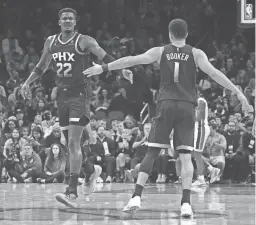  ?? PATRICK BREEN/THE REPUBLIC ?? Suns guard Devin Booker (1) and center Deandre Ayton (22) celebrate a basket against the Pistons during a game on Friday.