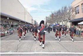  ?? CASEY JONES FOR THE SAVANNAH MORNING NEWS ?? A pipe and drum band moves along Broughton Street during the Savannah St. Patrick's Day Parade on Saturday.