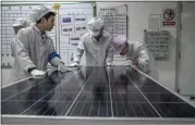  ?? GILLES SABRIÉ — THE NEW YORK TIMES ?? Workers perform a quality check on a solar panel production line at a factory in Suzhou, China, in 2019.