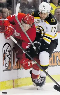  ?? CARLOS OSORIO/THE Associated Press ?? Boston’s Milan Lucic, right, checks Detroit’s Brendan Smith during the first period Tuesday in Game 3 at Joe Louis Arena. The Bruins won 3-0 to take a 2-1 lead in the series.