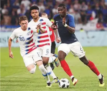  ?? AP ?? Above: France’s Paul Pogba (right) battles for the ball with United States’ Will Trapp (left) and Weston McKennie during a friendly match at the Groupama stadium.Right: Tunisia’s Ferjani Sassi (left) fights for possession with Spain’s Iago Aspas during a friendly.