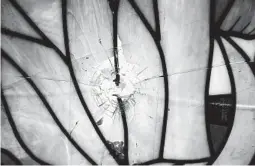  ??  ?? A bullet hole pierced a window of the chapel at a Catholic church in Managua, Nicaragua, where student protesters took refuge in July 2018.