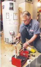  ?? MICHAEL CHRITTON/AKRON BEACON JOURNAL ( TNS) ?? Steven Racin, an installer for Jennings Heating & Cooling Co., Inc., solders a joint as he prepares to install a new hot water heater in a home in Akron, Ohio.