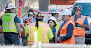  ?? Allen J. Schaben
Los Angeles Times ?? CONSTRUCTI­ON WORKERS
gather Thursday after a man fell from the 53rd f loor of the Wilshire Grand.