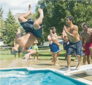  ?? HARRY FISHER/THE MORNING CALL PHOTOS ?? Dieruff High School football safety Jayden Reyes dives into the pool prior to the team watching its head coach take the Ice Bucket Challenge to benefit ALS during a Dieruff alumni picnic at the home of John Hughes in Lower Saucon Township on Aug. 24, 2014.