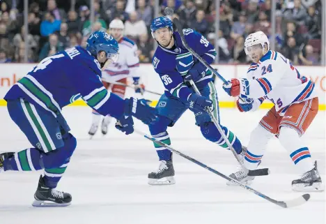  ?? DARRYL DYCK/THE CANADIAN PRESS ?? Vancouver Canucks forward Jannik Hansen, centre, battles New York Rangers’ Oscar Lindberg, right. ‘Special teams are so important in this league and you see what they can do when they are going for you,’ Hansen said of the Canucks’ perfect penalty-kill...