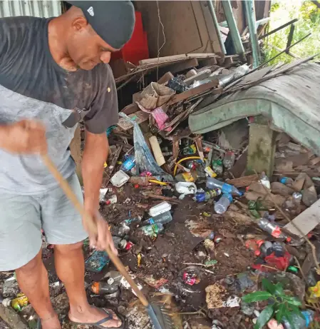  ?? ?? A member of the Exodus Club clearing rubbish at a home in Naikabula, Lautoka.