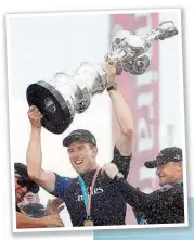  ??  ?? Peter Burlint mit der Silberkann­e. Er ist mit 26 Jahren der jüntste Steuermann, der den America’s Cup tewann.