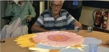  ??  ?? A patient with dementia tries out the new magic table aimed at stimulatin­g them