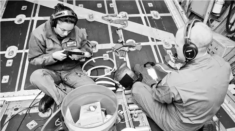  ??  ?? Petty Officer second Class Mandi Stevens and Petty Officer second Class Chris Parmenter, aviation maintenanc­e technician­s from US Coast Guard Air Station Barbers Point, Hawaii, prepare a long range deployable drop kit to a disabled vessel approximat­ely...