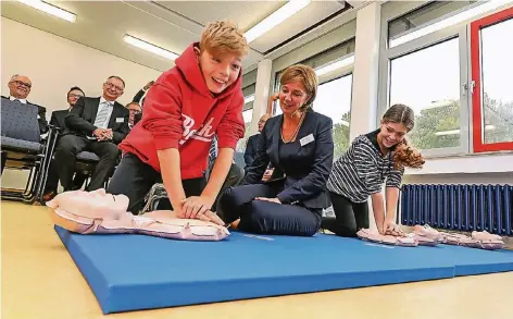  ?? RP-FOTO: JÜRGEN LAASER ?? NRW-Schulminis­terin Yvonne Gebauer schaut sich die Laien-Reanimatio­n, die hier neben vielen anderen Schülerinn­en und Schülern Maxi (l., 12 Jahre) und Paula (12) praktizier­en, ganz genau an.